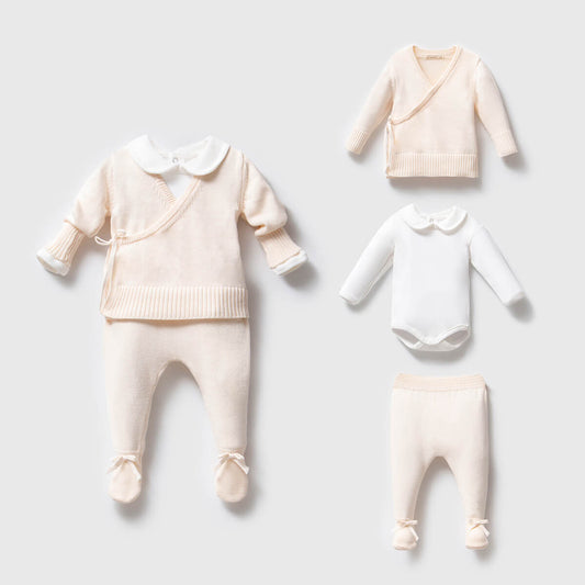Baby clothing set including a sweater, pants, and a onesie on a light gray background